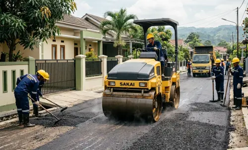 Pemadatan aspal hotmix menggunakan tandem roller pada proyek pengaspalan jalan perumahan oleh jasa pengaspalan sumedang