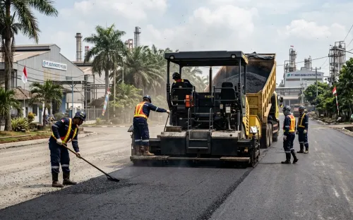 Proses pengerjaan jasa pengaspalan Purwakarta oleh tim profesional menggunakan mesin finisher di kawasan industri
